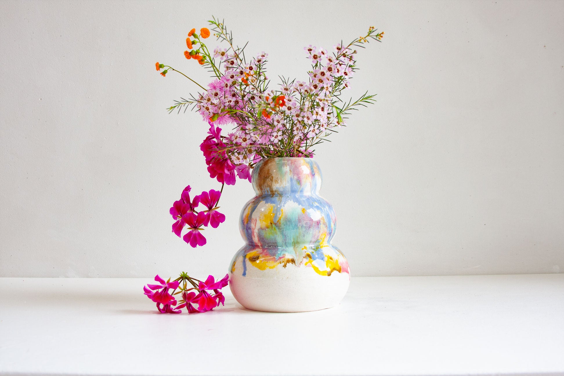 Decorative vase with colorful floral design on a white surface and background