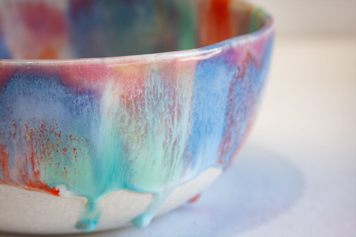 Colorful ceramic bowl with a multicolored glaze on a white background