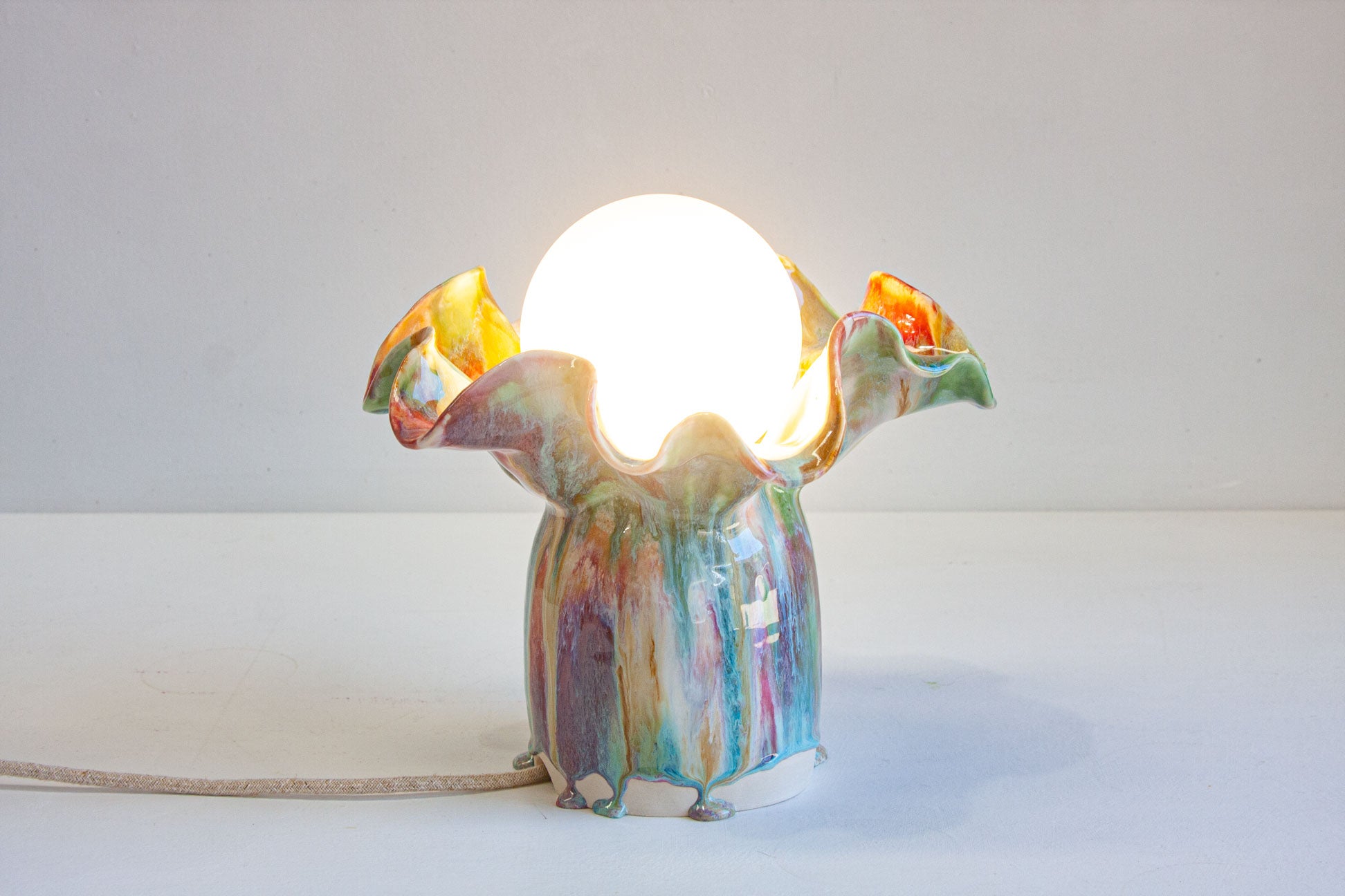 handmade ceramic lamp shown with light on 