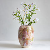 Decorative vase with marbled pattern and small flowers on a plain background