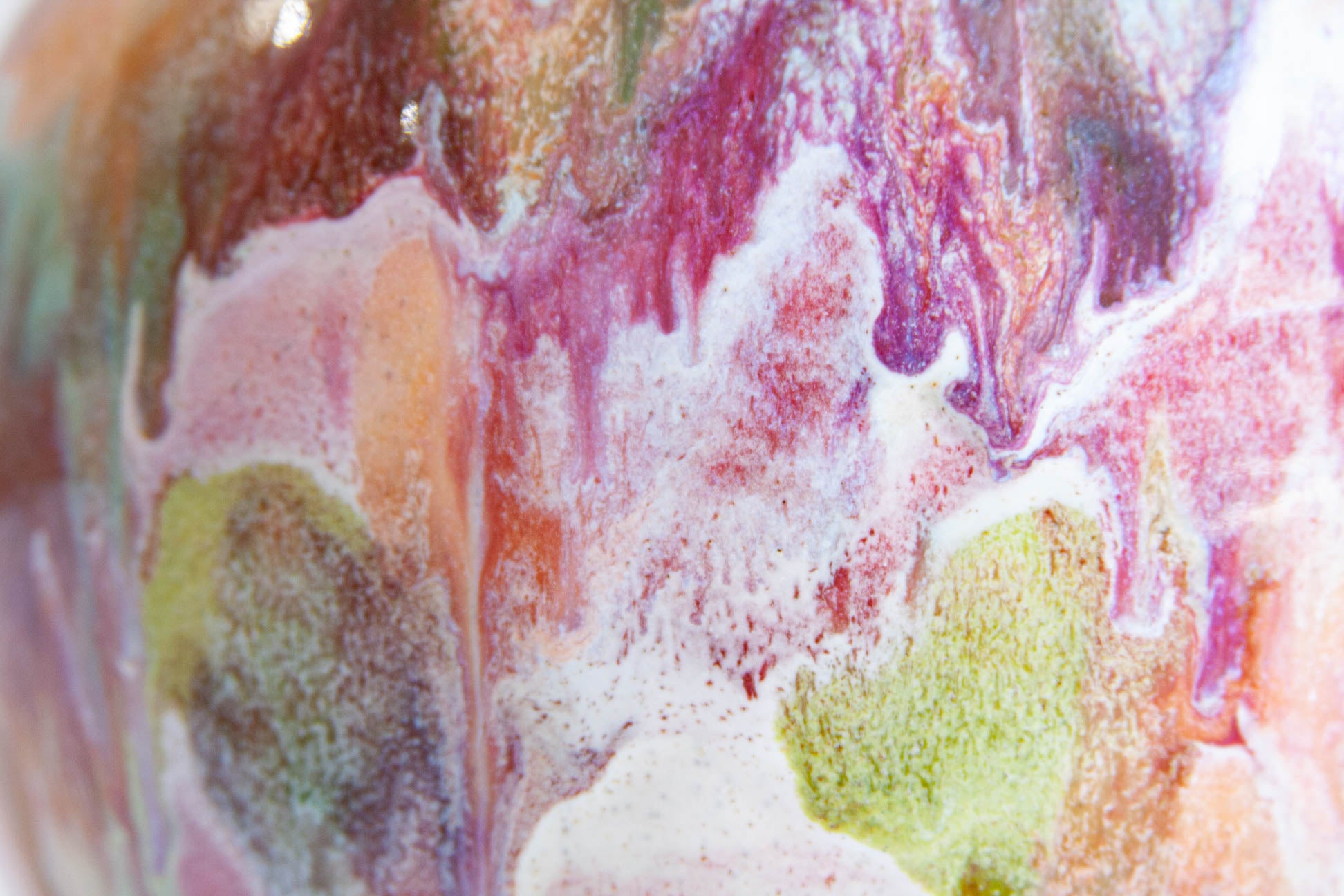 Abstract close-up of a marbled, fluid-art surface with swirling pink, purple, peach, olive green, and white textures.