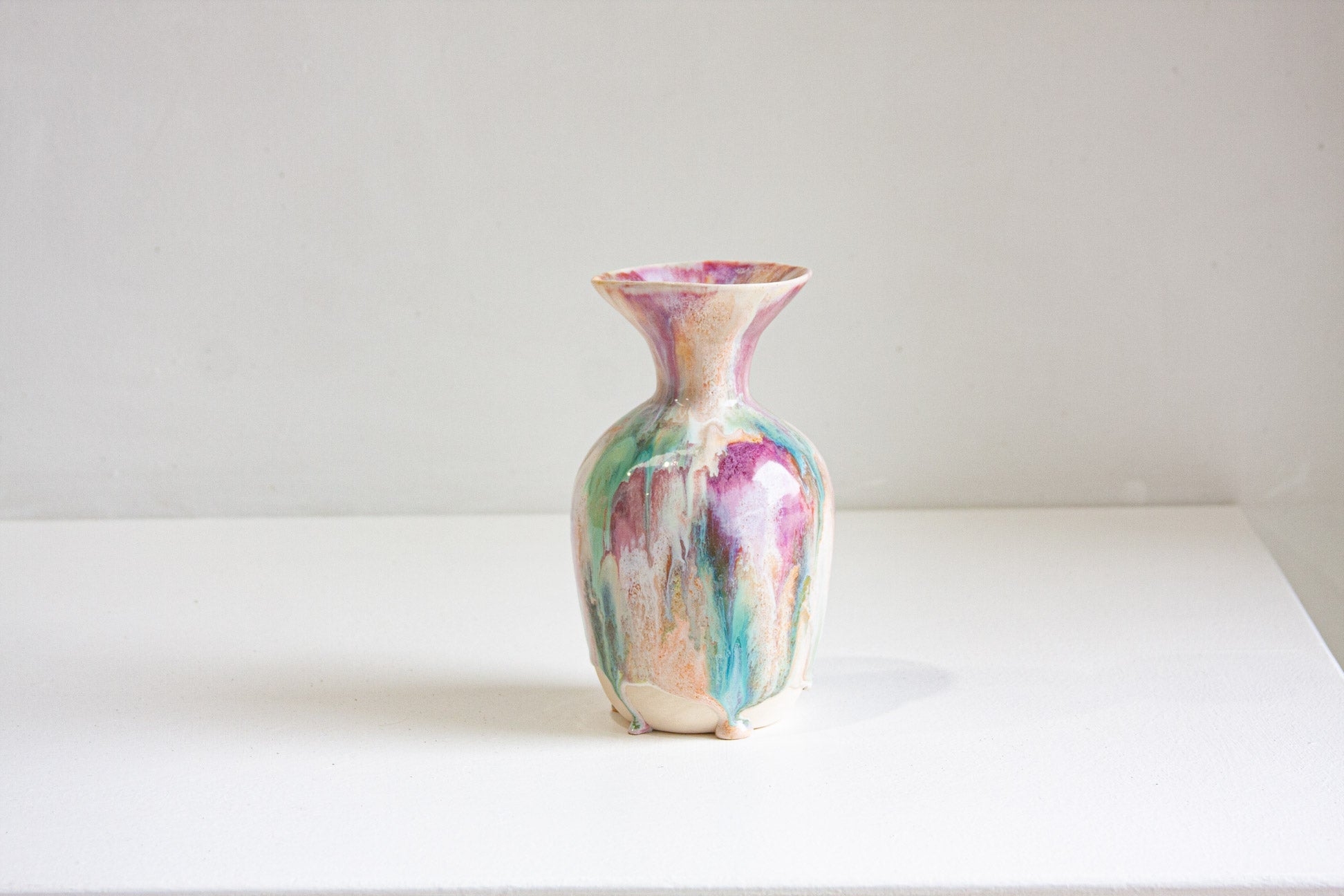 Multicolored vase on a white surface with a white background