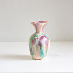 Multicolored vase on a white surface with a white background
