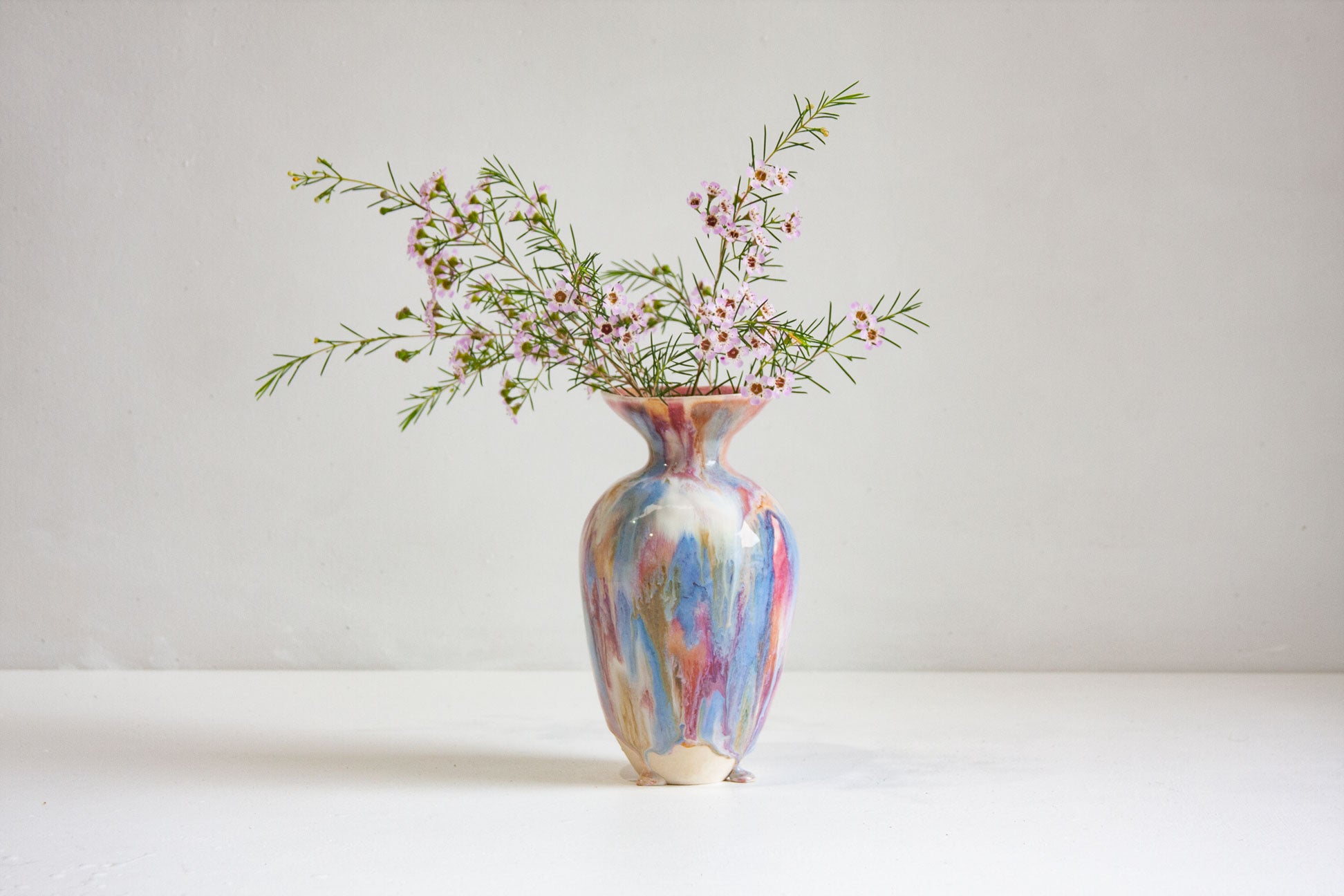 Multicolored vase with flowers on a white background