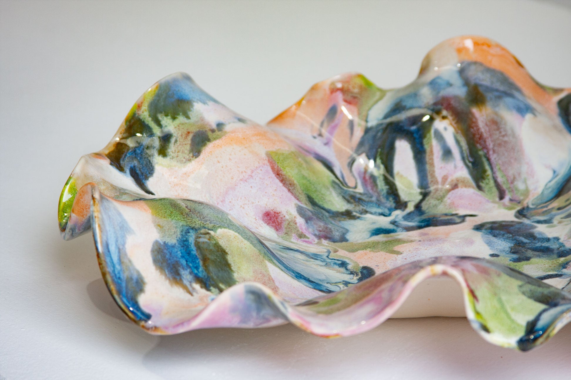 Colourful ceramic shell shaped platter on a white background