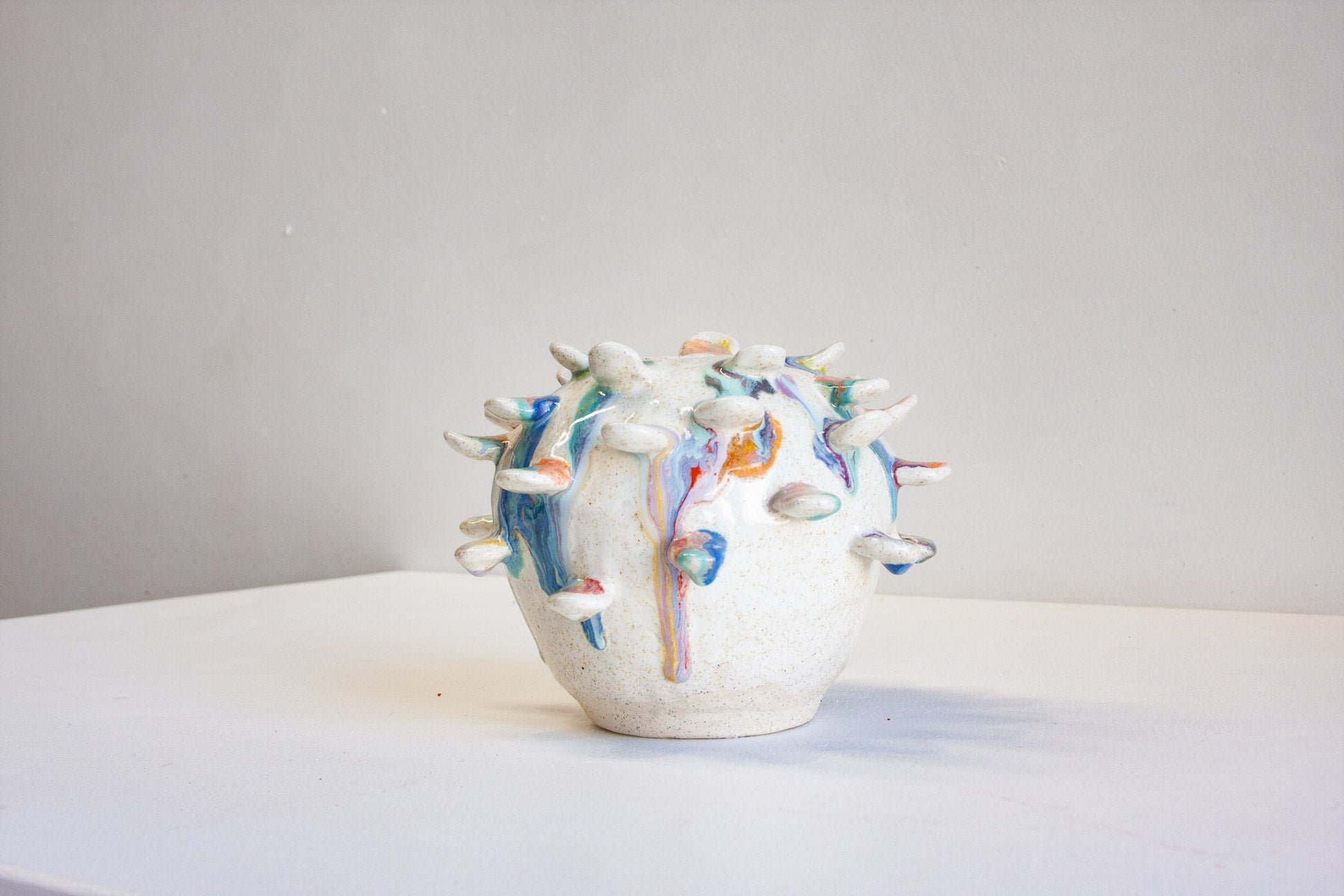 handmade ceramic vase with attached colourful petals