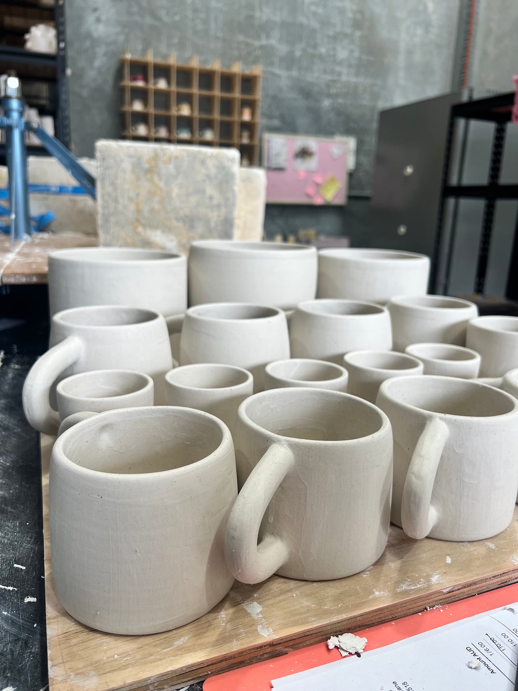 a group of handmade ceramic mugs being produced by rhiannon gill at the leather hard stage